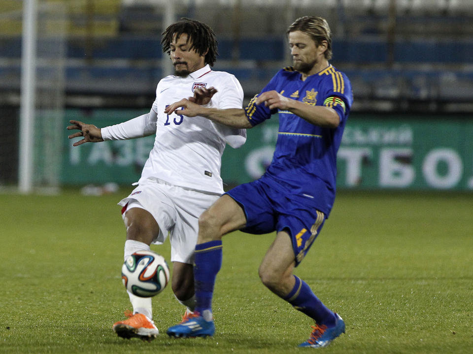 Anatroliy Tymoshchuk, right, of Ukraine fights for the ball with Jermaine Johns of U.S. during an international friendly match at Antonis Papadopoulos stadium in southern city of Larnaca, Cyprus, Wednesday, March 5, 2014. The Ukrainians are face the United States in a friendly on Wednesday in Cyprus, a match moved from Kharkiv to Larnaca for security reasons. (AP Photo/Petros Karadjias)