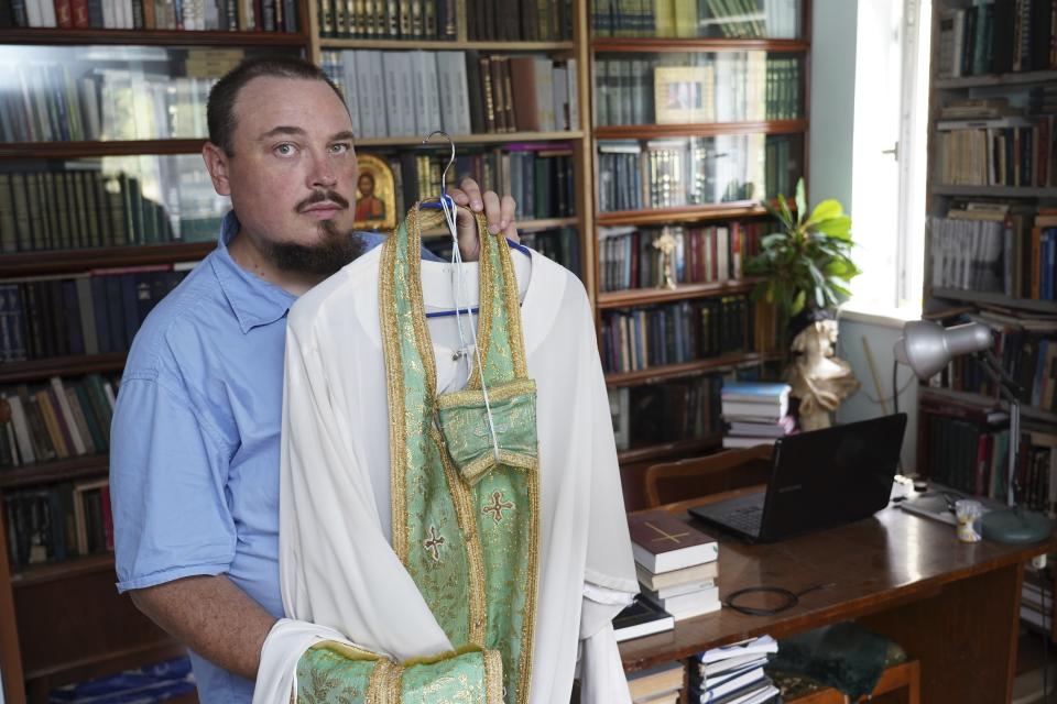 The Rev. Iakov Vorontsov holds his liturgical vestment in his apartment in Almaty, Kazakhstan, on Wednesday, Aug. 9, 2023. Vorontsov, a priest in Kazakhstan, was shocked and desperate when he first heard that Russia sent troops into Ukraine. He was hoping the church would step in to mediate the conflict. But his calls to preach peace received no support: his superiors reassigned him several times, forbade him from giving sermons, and told parishioners to stay away from him. In the end, Vorontsov decided to temporarily stop serving. (Vladimir Tretyakov/NUR.KZ via AP)