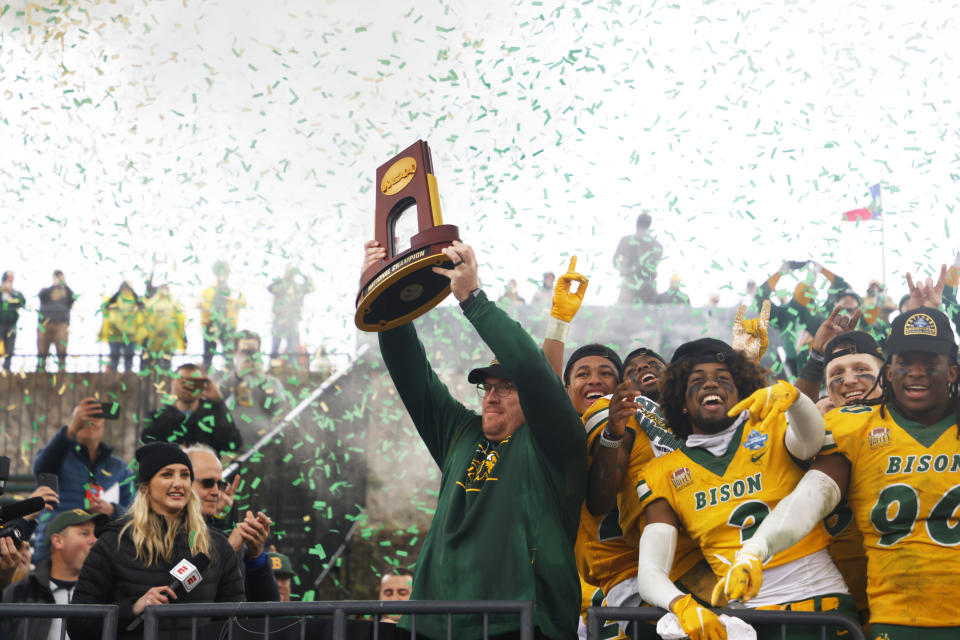 North Dakota State head coach Matt Entz holds up the championship trophy as he celebrates with linebacker Jasir Cox (3) and defensive end Tony Pierce (90) after the FCS Championship NCAA college football game against Montana State, Saturday, Jan. 8, 2022, in Frisco, Texas. (AP Photo/Michael Ainsworth)