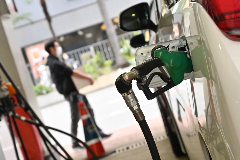 Petrol station attendants fill up vehicles at a petrol station in Hong Kong on March 7, 2022 with fuel prices rising as traders fretted over the fallout from Russia's invasion of Ukraine. (Photo by Peter PARKS / AFP) (Photo by PETER PARKS/AFP via Getty Images)