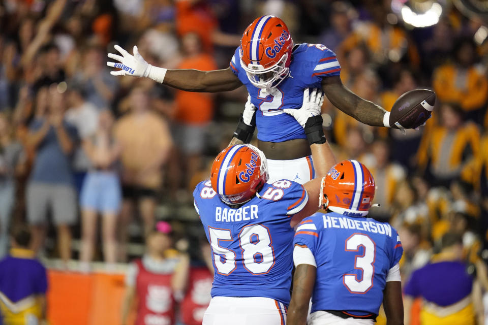 Florida running back Montrell Johnson Jr. (2) celebrates with teammates offensive lineman Austin Barber (58) and wide receiver Xzavier Henderson after his touchdown against LSU during the first half of an NCAA college football game, Saturday, Oct. 15, 2022, in Gainesville, Fla. (AP Photo/John Raoux)