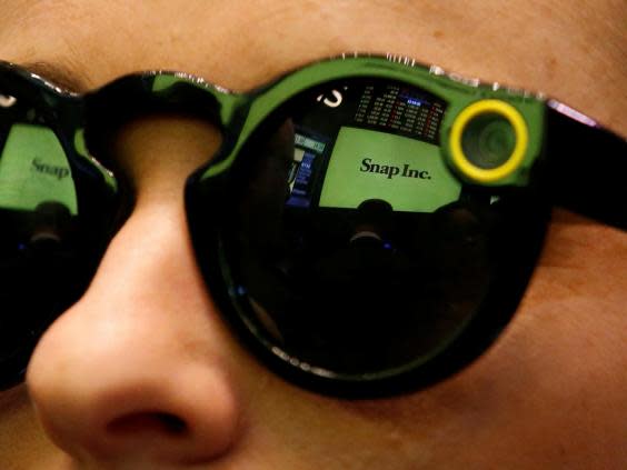 A woman wears Snapchat Spectacles on the floor of the New York Stock Exchange (NYSE) while waiting for Snap Inc. to list their IPO in New York, U.S., March 2, 2017 (REUTERS/Brendan McDermid)