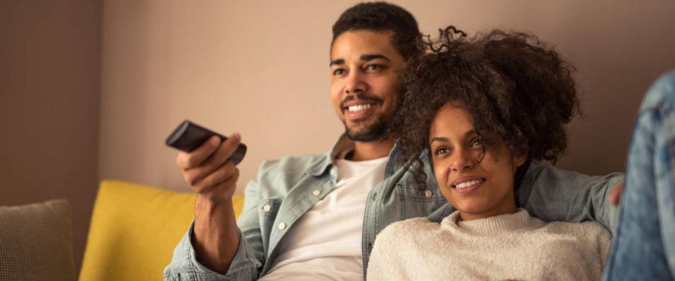 Cropped shot of a young african american couple watching television at home