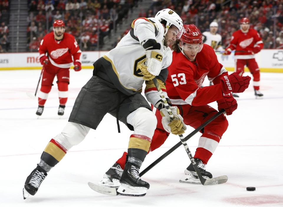 Vegas Golden Knights center Paul Cotter, front left, drives toward the goal against Detroit Red Wings defenseman Moritz Seider (53) during the second period of an NHL hockey game Saturday, Jan. 27, 2024, in Detroit. (AP Photo/Duane Burleson)