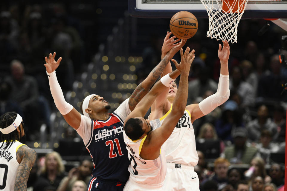 Washington Wizards center Daniel Gafford (21) and Utah Jazz center Walker Kessler (24) and guard Talen Horton-Tucker (0) reach for the ball during the first half of an NBA basketball game Saturday, Nov. 12, 2022, in Washington. (AP Photo/Nick Wass)