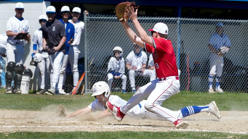Cumberland runner Luke Plumer slides safely home under Cranston West pitcher Jack Fontaine to score for the Clippers earlier this season.