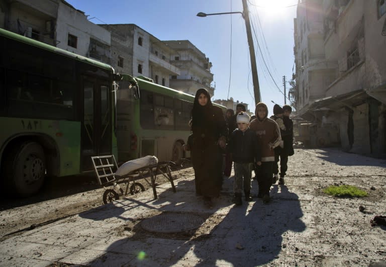 Syrians gather during an evacuation operation of rebel fighters and civilians from rebel-held neighbourhoods of Aleppo