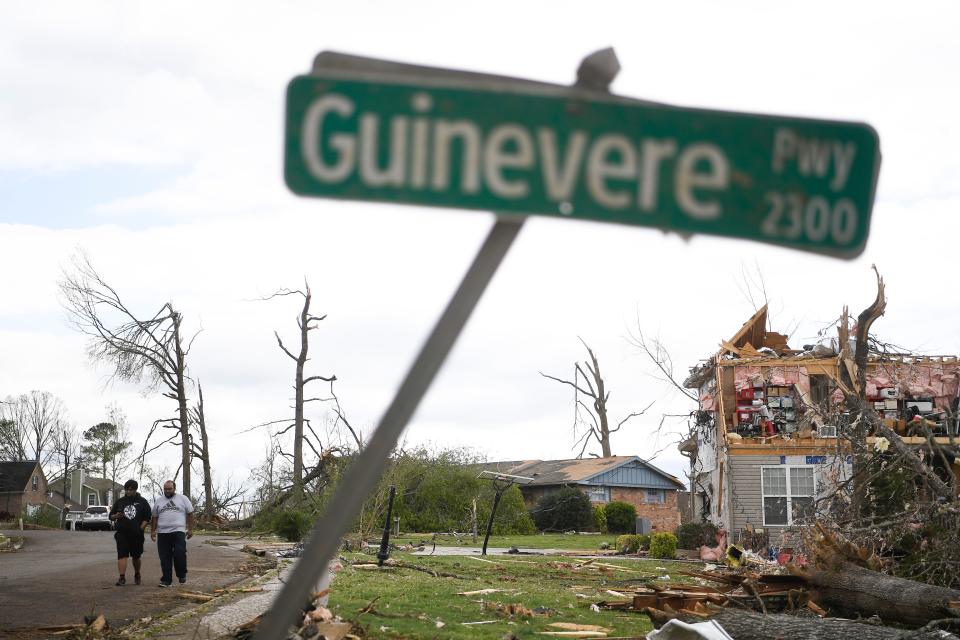 People walk through the damaged Drake Forest neighborhood in Chattanooga on April 13, 2020.