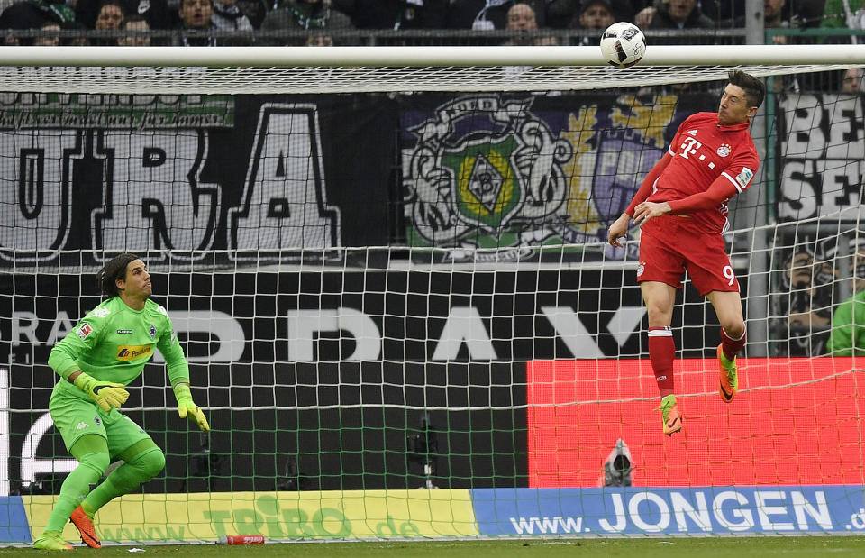 Bayern's Robert Lewandowski jumps for the ball beside Moenchengladbach goalkeeper Yann Sommer during the German Bundesliga soccer match between Borussia Moenchengladbach and Bayern Munich in Moenchengladbach, Germany, Sunday, March 19, 2017. (AP Photo/Martin Meissner)