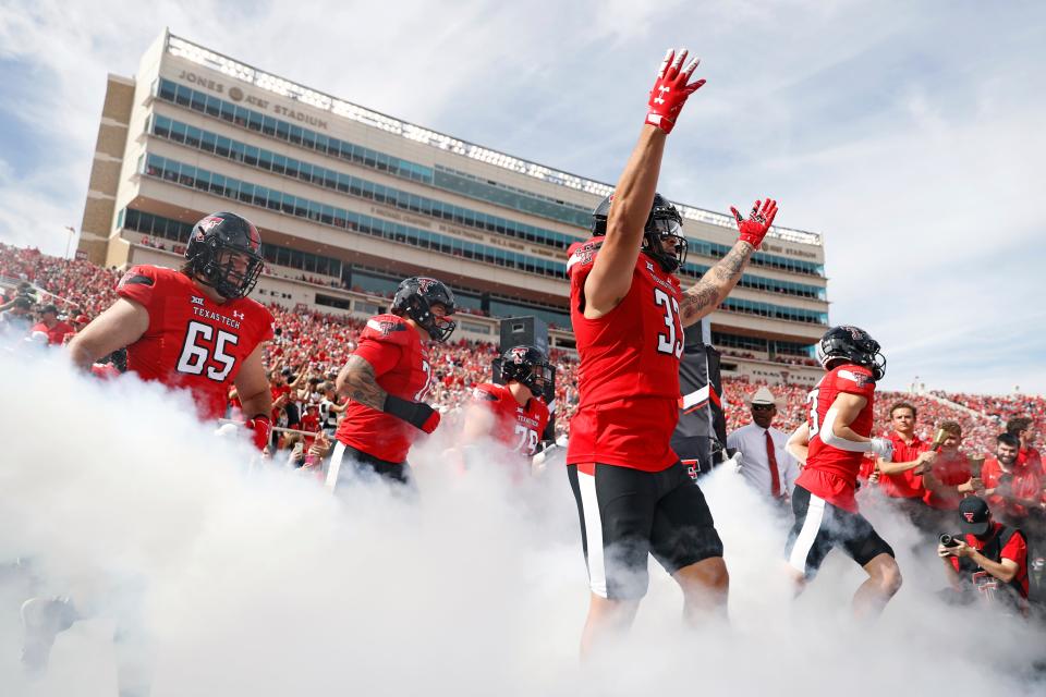 Texas Tech's Matthew Young (33) raises his arms while running onto the field before an NCAA college football game against West Virginia, Saturday, Oct. 22, 2022, in Lubbock, Texas. (AP Photo/Brad Tollefson)