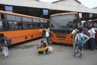 Migrant workers wait for transportation after having their COVID-19 tests done upon arrival in New Delhi, India, Tuesday, Aug. 18, 2020. The lockdown imposed in late March cost more than 10 million impoverished migrant workers their jobs in the cities. Many made grueling journeys back to their hometowns and villages. Now they face the ordeal of trying to get back to their factory jobs. (AP Photo/Manish Swarup)