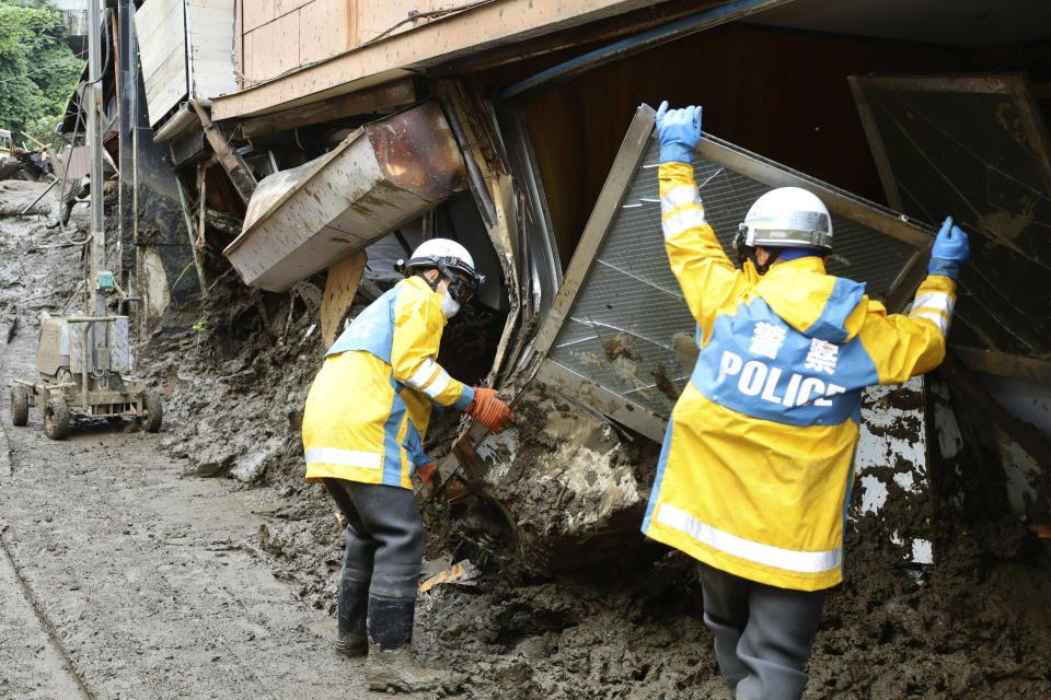 Police officers continue a search operation for missing people at the site of a mudslide in Atami, southwest of Tokyo Tuesday, July 6, 2021. Rescue workers struggled with sticky mud and risks of more mudslides Tuesday as they searched for people may have been trapped after a torrent of mud that ripped through a seaside hot springs resort. (Kyodo News via AP)