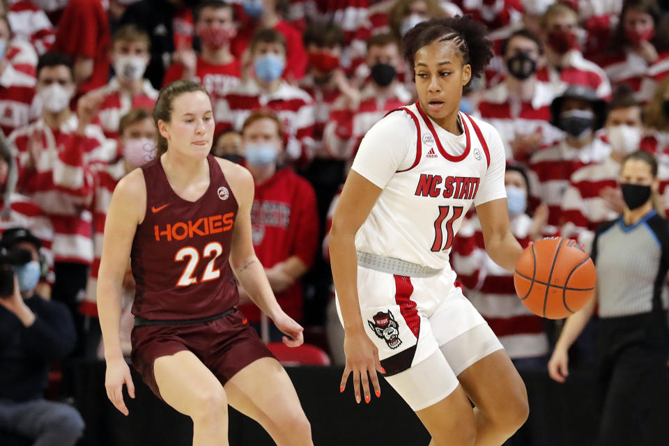 North Carolina State's Jakia Brown-Turner (11) controls the ball in front of Virginia Tech's Cayla King (22) during the first half of an NCAA college basketball game, Sunday, Jan. 23, 2022, in Raleigh, N.C. (AP Photo/Karl B. DeBlaker)