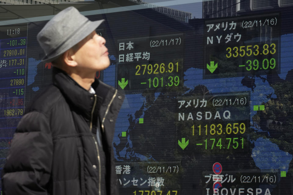 A person walks in front of an electronic stock board showing Japan's Nikkei 225 index, center left, at a securities firm Thursday, Nov. 17, 2022, in Tokyo. Asian shares mostly declined Thursday amid concerns about the impact of China's "zero-COVID" strategy mixed with hopes for economic activity and tourism returning to normal. (AP Photo/Shuji Kajiyama)