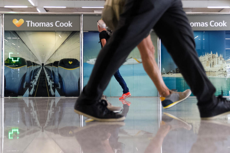 Passengers walk past a closed Thomas Cook office at Palma de Mallorca airport on Monday Sept. 23, 2019. Spain's airport operator AENA says that 46 flights have been affected by the collapse of the British tour company Thomas Cook, mostly in the Spanish Balearic and Canary archipelagos. (AP Photo/Francisco Ubilla)