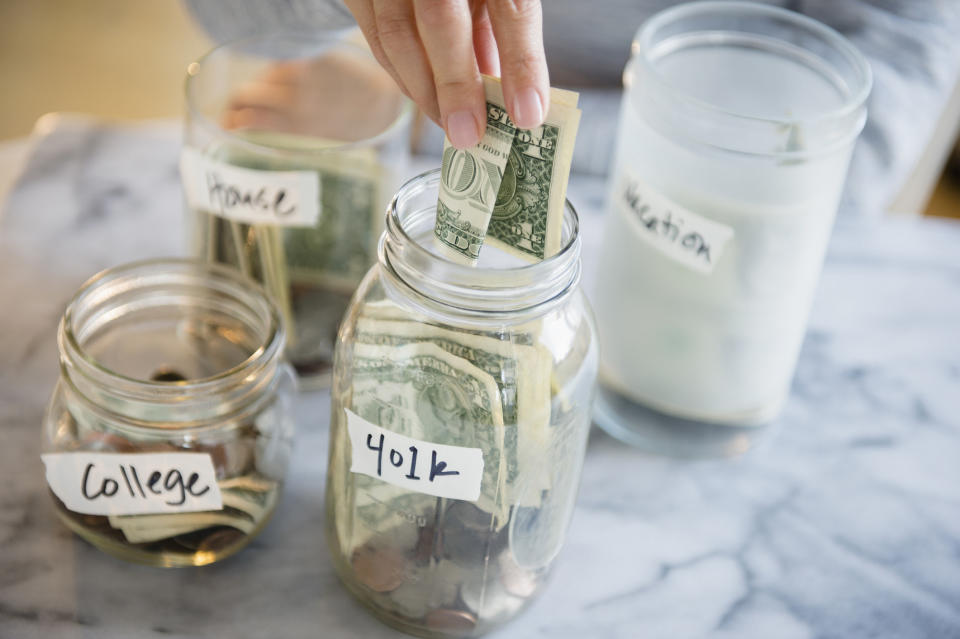 Someone putting money into a jar labeled "401K"