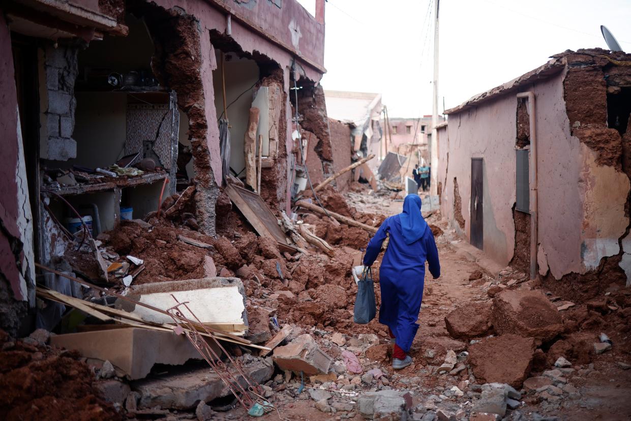 File photo: A woman passes by damaged buildings following a powerful earthquake in Ouirgane, south of Marrakesh (EPA)