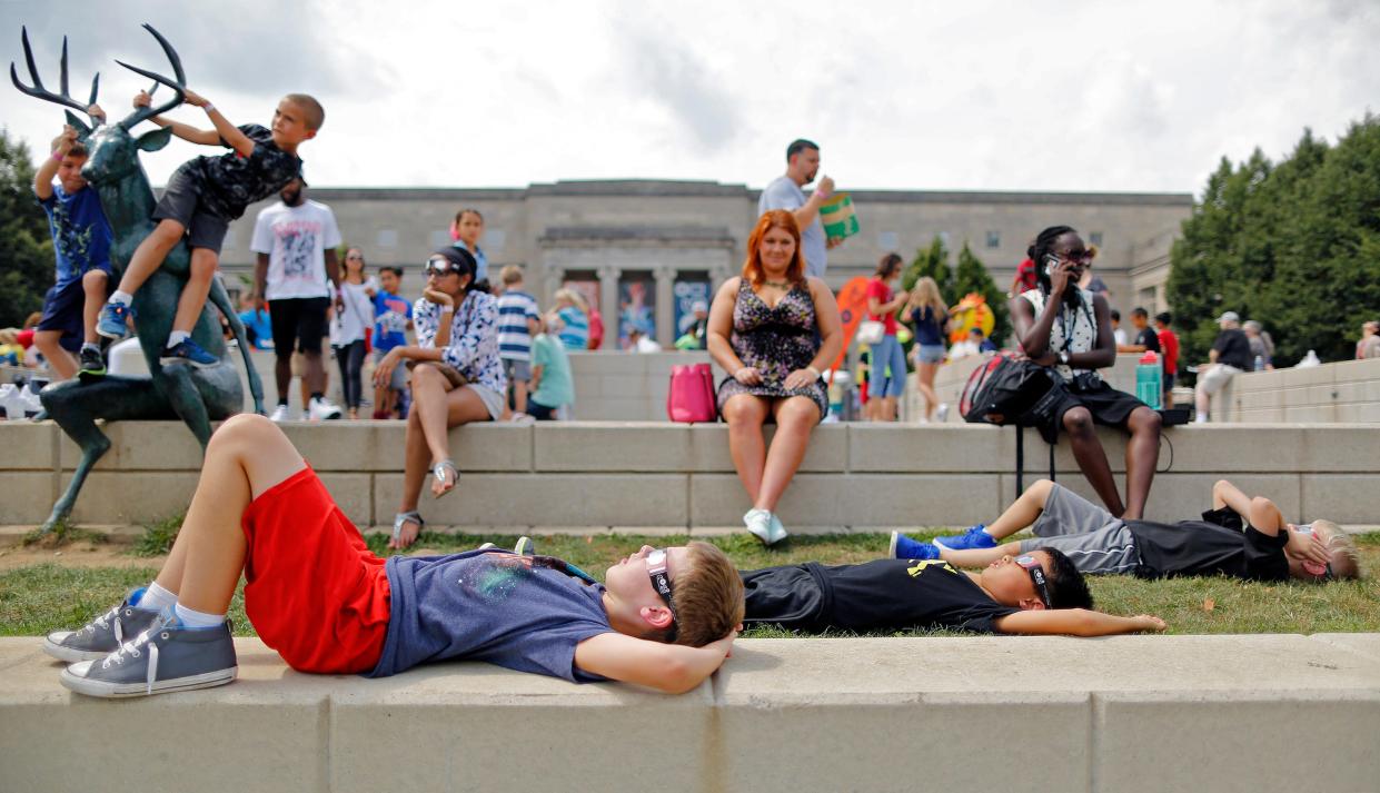 4th graders Ryan Steward, 9, left, Linden Marim, 9, center, and Drew Adamkosky, 9, right, from Oak Creek elementary in Olentangy watch the start of the solar eclipse during the COSI solar eclipse watch party in Columbus, Ohio on August 21, 2017. [Kyle Robertson/Dispatch]