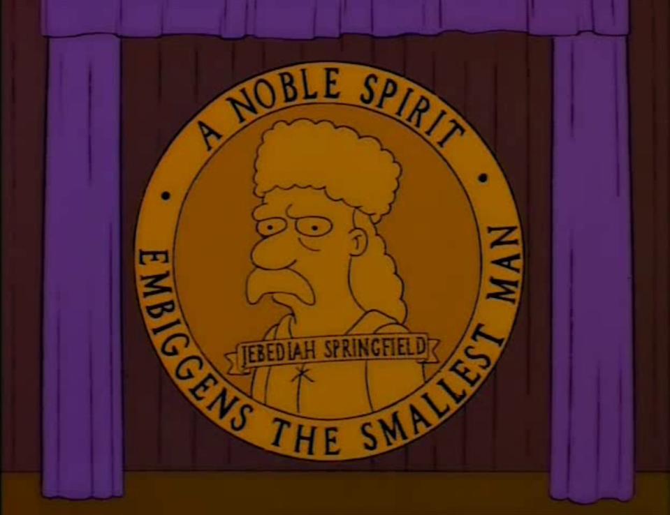 A giant emblem of Jebediah Springfield against a purple curtain from The Simpsons