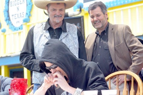 Big Texan Steak Ranch co-owners Bobby, left, and Danny Lee watch as Molly Schuyler consumes a 72-ounce steak Sunday, April 19. (Sean Steffen / Amarillo Globe-News)