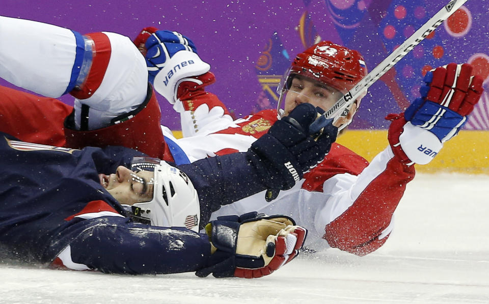 USA forward Max Pacioretty and Russia forward Valeri Nichushkin hit the ice in the second period of a men's ice hockey game at the 2014 Winter Olympics, Saturday, Feb. 15, 2014, in Sochi, Russia. (AP Photo/Julio Cortez)