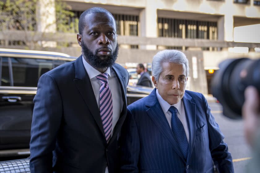 Prakazrel "Pras" Michel and his defense lawyer David Kenner walking out of black SUV, both wearing dark blue suits