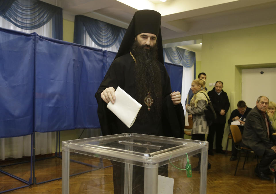 An Orthodox priest casts his ballot paper at a polling station in Kiev, Ukraine, Sunday, Oct. 28, 2012. Voters in Ukraine are choosing a new parliament Sunday. (AP Photo/Efrem Lukatsky)