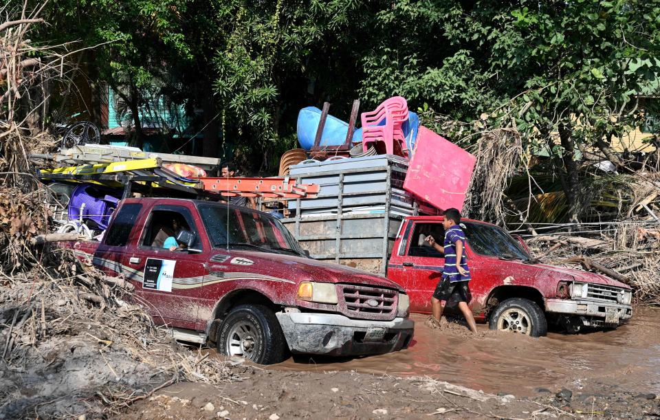 Workers of banana fields come across a flooded road while evacuating the area in El Progreso, Honduras, on Nov. 14, 2020, before the arrival of tropical storm Iota.