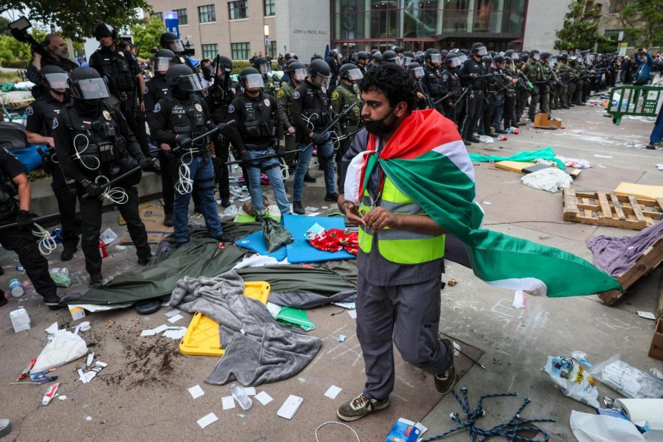 A pro-Palestinian demonstrator walks along a police line at UC Irvine.