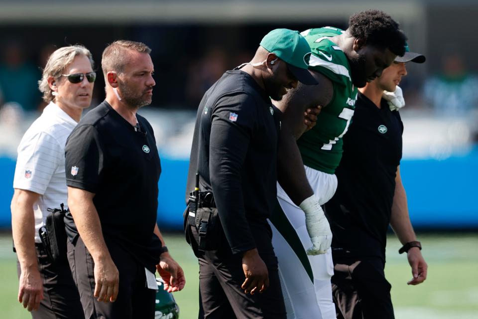 New York Jets offensive tackle Mekhi Becton is helped off the field during the second half of an NFL football game against the Carolina Panthers Sunday, Sept. 12, 2021, in Charlotte, N.C. (AP Photo/Nell Redmond)