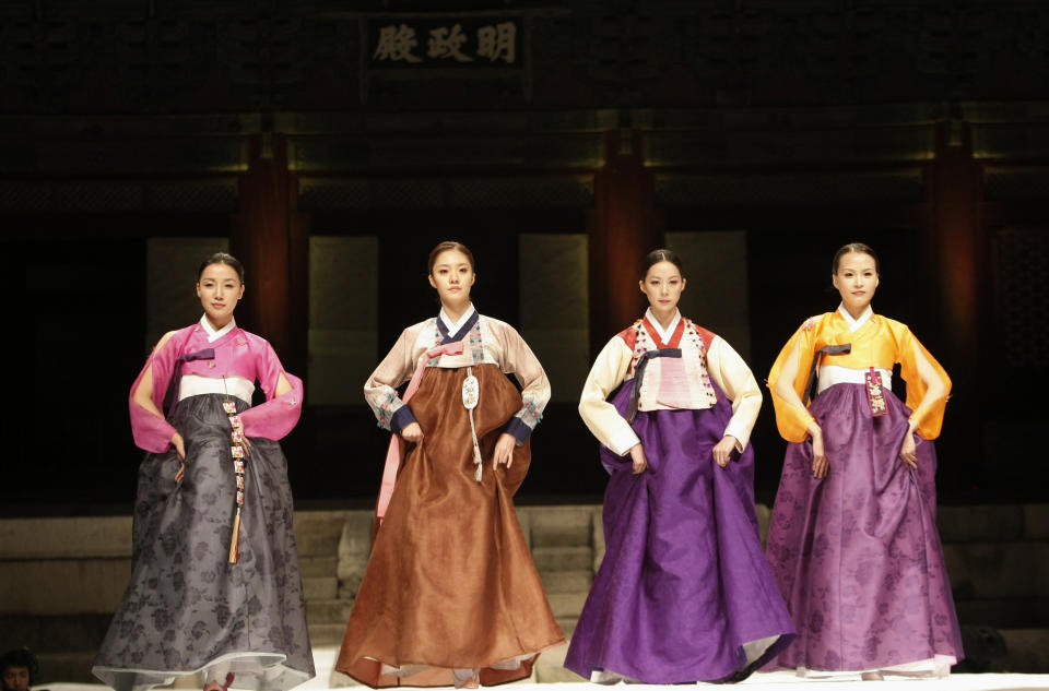 <p>Der bunte Hanbok besteht aus mehreren Schichten Seidenstoff und wird im Winter durch eine dicke Hose unter dem unter der Brust gebundenem Rock ergänzt. Oberhalb der Taille wird eine kurze Jacke mit weiten Ärmeln und einer großen Schleife vor der Brust getragen. Außerhalb des Hauses tragen die Frauen bunte Gummischuhe dazu. (Bild: AP Photo) </p>