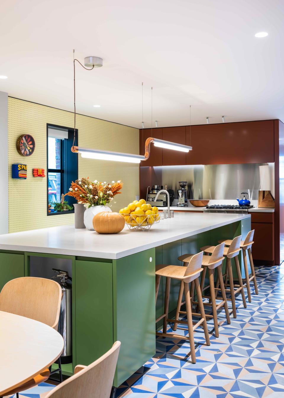 The oversized kitchen island, with Muuto’s Nerd Counter Stools, makes for a perfect casual eat-in space. It faces a pegboard wall, which shows off pieces from the couple’s eclectic art collection.