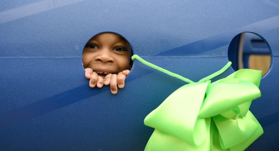 Zayda Washington, 4, peeks out of an opening as JRC Learning Center dedicates new playground equipment at the JRC Myrna Pastore Campus in Canton Township.