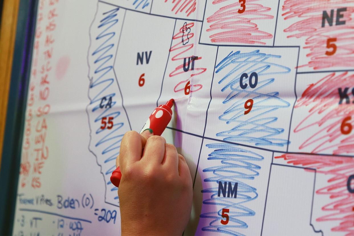 WELLINGTON, NEW ZEALAND - NOVEMBER 04: A woman colors Utah in red on an electoral college map to mark a Republican party win at an event at Lulu Bar on November 04, 2020 in Wellington, New Zealand hosted by the United States Embassy and the NZ U.S Council to watch the results of the 2020 U.S election come through. After a record-breaking early voting turnout across the United States, Americans have headed to the polls on the last day to cast their vote for incumbent U.S. President Donald Trump or Democratic nominee Joe Biden in the 2020 presidential election. (Photo by Lynn Grieveson - Newsroom/Newsroom via Getty Images)