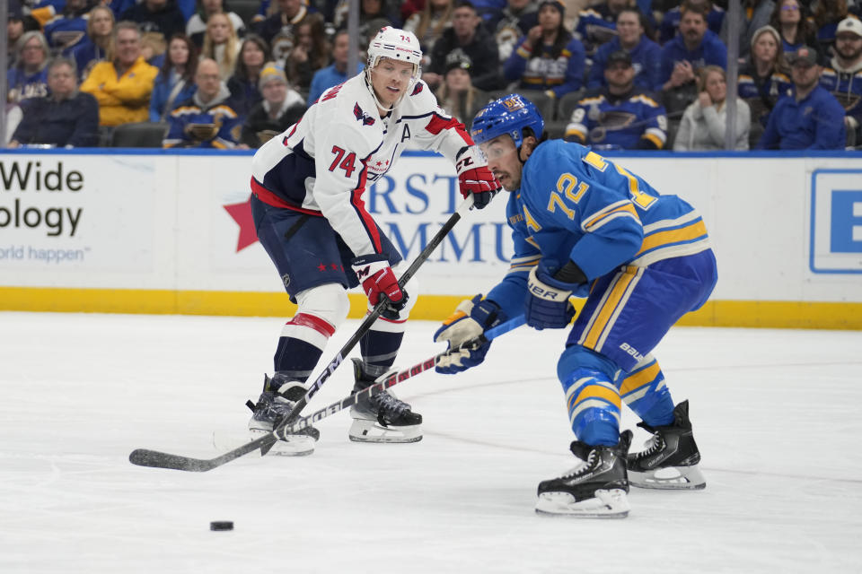 Washington Capitals' John Carlson (74) passes around St. Louis Blues' Justin Faulk (72) during the first period of an NHL hockey game Saturday, Jan. 20, 2024, in St. Louis. (AP Photo/Jeff Roberson)