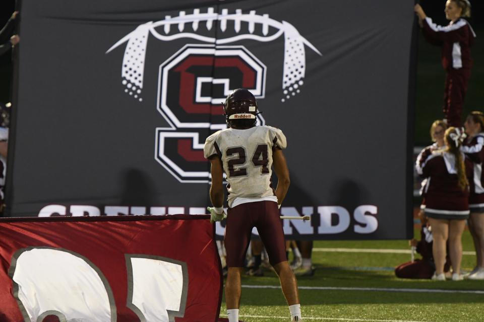 Amari Kerr (24) waves the flag as his team arrives. Shippensburg visited Gettysburg on Friday, September 30, 2022