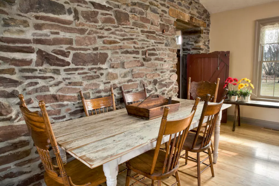 <p>The open-concept dining room has beautiful brick walls. (Airbnb) </p>