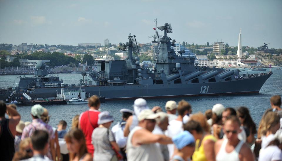 A crowd of people in front of the Moskva ship.