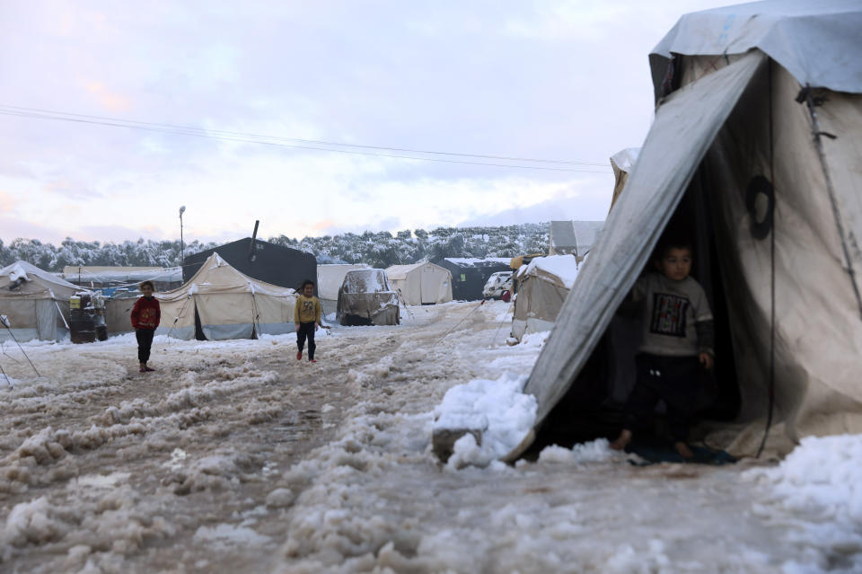 Displaced Syrian children walk in the snow at a refugee camp, in Afrin, north of Aleppo, Syria, Wednesday, Jan. 19, 2022. A snowstorm in the Middle East has left many Lebanese and Syrians scrambling to find ways to survive. Some are burning old clothes, plastic and other hazardous materials to keep warm as temperatures plummet and poverty soars. (AP Photo/Ghaith Alsayed)