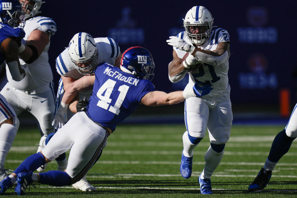 Indianapolis Colts' Zack Moss (21) rushes past New York Giants' Micah McFadden (41) during the first half of an NFL football game, Sunday, Jan. 1, 2023, in East Rutherford, N.J. (AP Photo/Seth Wenig)