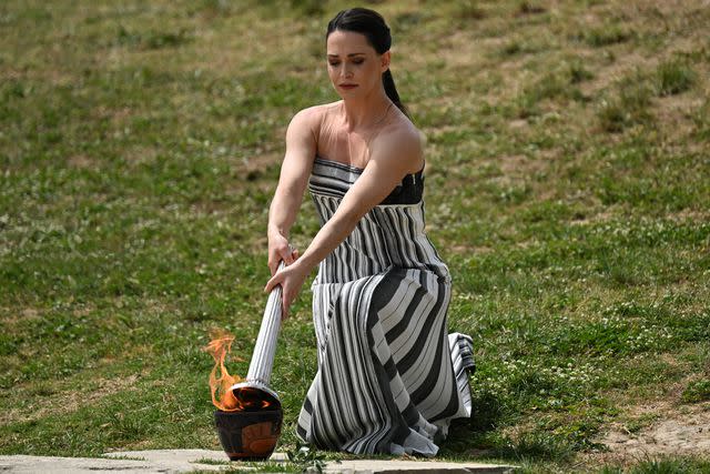 <p>ARIS MESSINIS/AFP via Getty</p> Mary Mina lights the Olympic torch for the Paris 2024 Olympics Game