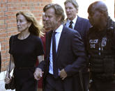 Felicity Huffman arrives at federal court with her husband William H. Macy and her brother Moore Huffman Jr., back, for sentencing in a nationwide college admissions bribery scandal, Friday, Sept. 13, 2019, in Boston. (AP Photo/Elise Amendola)