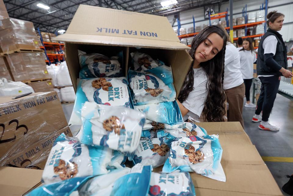 Raquel Falabella unboxes dry milk to distribute in food boxes during a service day, hosted by The Church of Jesus Christ of Latter-day Saints, to commemorate the 10th anniversary of its relationship with the United Nations World Food Programme and World Food Program USA, at Bishops’ Central Storehouse in Salt Lake City on Thursday, Feb. 8, 2024. | Kristin Murphy, Deseret News
