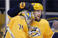 Nashville Predators right wing Viktor Arvidsson (33) congratulates goaltender Juuse Saros (74) after a 5-2 win over the Columbus Blue Jackets in an NHL hockey game Saturday, Jan. 16, 2021, in Nashville, Tenn. (AP Photo/Mark Humphrey)