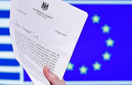 EU Council President Donald Tusk holds British Prime Minister Theresa May's Brexit letter, which was delivered by Britain's permanent representative to the European Union Tim Barrow (not pictured) that gives notice of the UK's intention to leave the bloc under Article 50 of the EU's Lisbon Treaty, in Brussels, Belgium, March 29, 2017. Picture taken March 29, 2017. REUTERS/Yves Herman