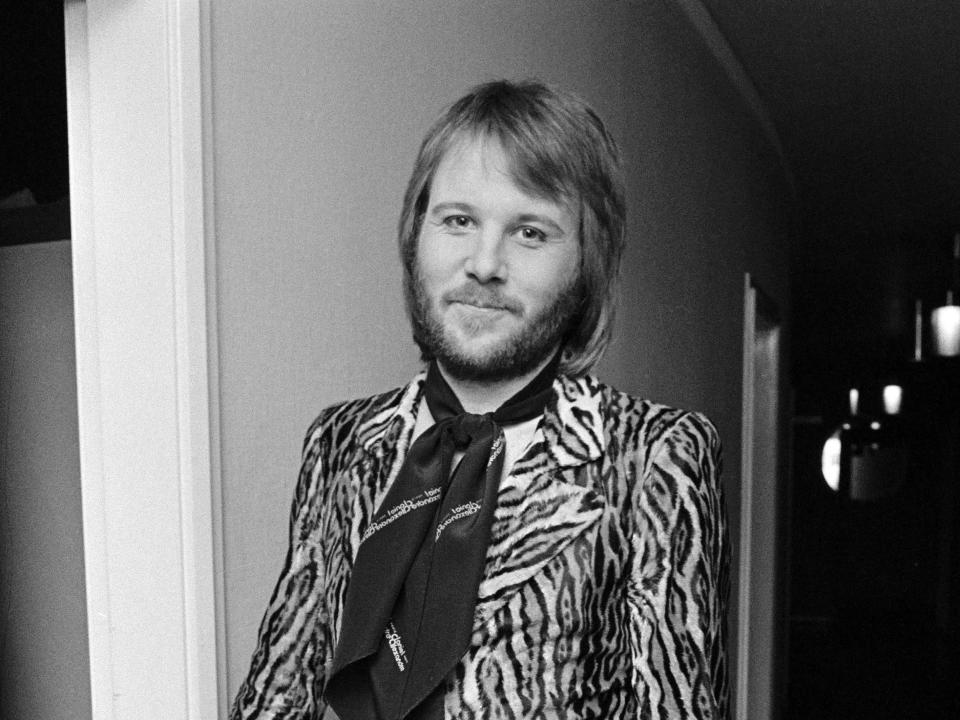Benny Andersson of ABBA poses backstage. He wears an animal print jacket with a necktie.