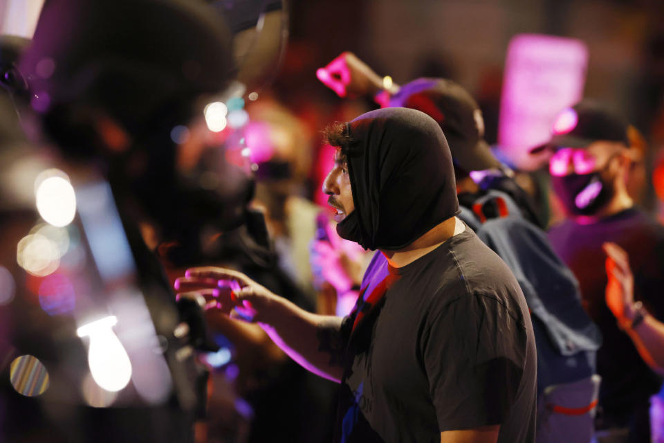 A man argues with Denver Police officers during a protest outside the State Capitol over the death of George Floyd, a handcuffed black man in police custody in Minneapolis, late Thursday, May 28, 2020, in Denver. (AP Photo/David Zalubowski)