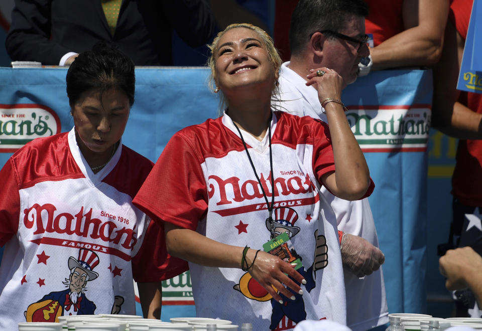 Miki Sudo, right, reacts after eating 31 hot dogs to win the women's competition of Nathan's Famous July Fourth hot dog eating contest, Thursday, July 4, 2019, in New York's Coney Island. (AP Photo/Sarah Stier)