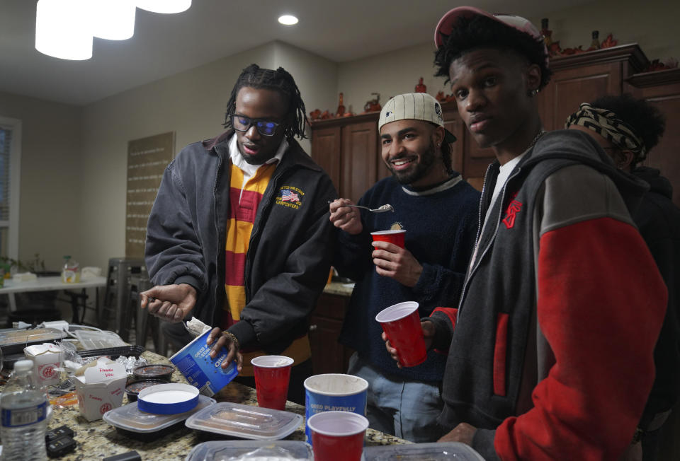 Two of The Cove's co-founders, Jonathan Diggs, left, Aaron Dews, center, and their friend Jeremiah Manley, left, eat ice cream at the Diggs' family home on Sunday, Feb. 18, 2024, in Nashville, Tenn. The Cove, an 18-and-up, pop-up Christian nightclub, was started last year by seven friends in their 20s who sought to build a thriving community and a welcoming space for young adults outside houses of worship. (AP Photo/Jessie Wardarski)