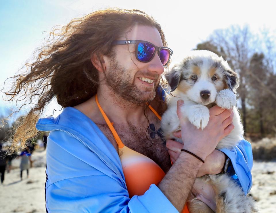 Scott Sanderson of Monroe Bridge, Mass., cuddles Fajita after diving into the ocean in the annual Doggie Paddle Plunge to benefit the NHSPCA in 2020.